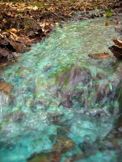 copper stained stream at the bottom of the site