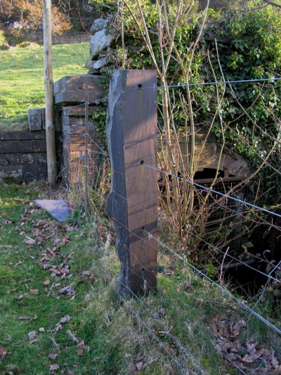 Slate fence post at side of drainage channel